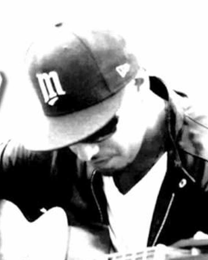 Maxx Cabello Jr. playing guitar in a black-and-white portrait